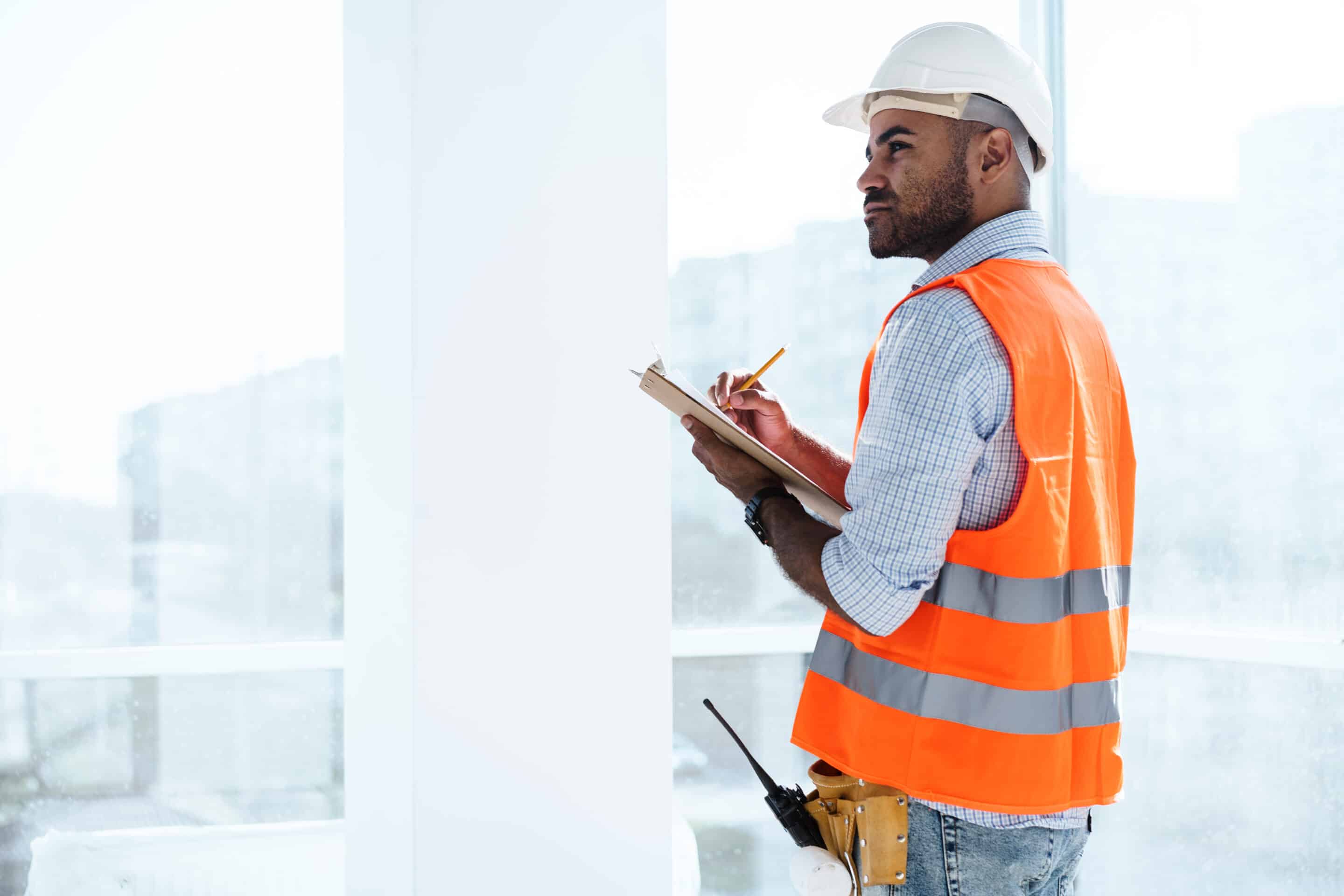 General contractor foreman reviewing clipboard on site